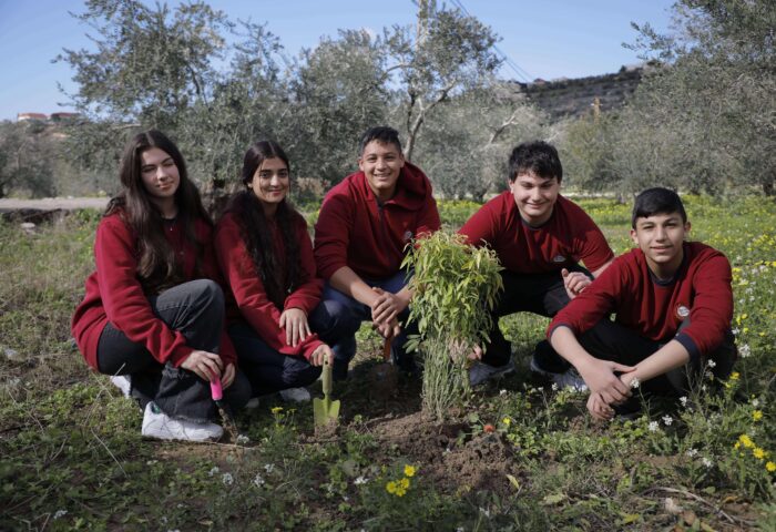 Grade 10 Stars College students planting a tree during sustainability project in Harsh Al-Abbasiyeh